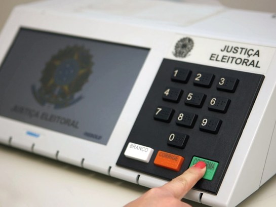 Urna votação Uma mão votando na Urna eletrônica